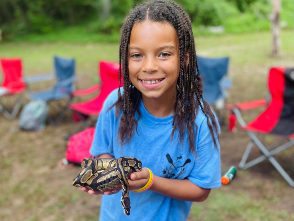 camper holding a snake at the nature program